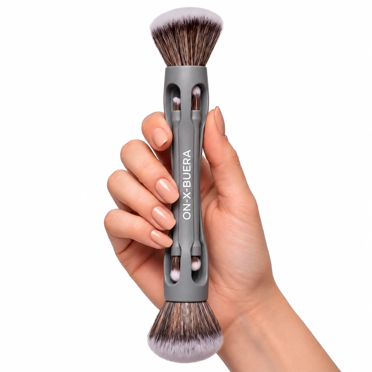 Elde tutulan gri gövdeli On-X-Buera çok uçlu makyaj fırçası; iki ucunda yoğun sentetik kıl, gövdede saklanan ince uçlar